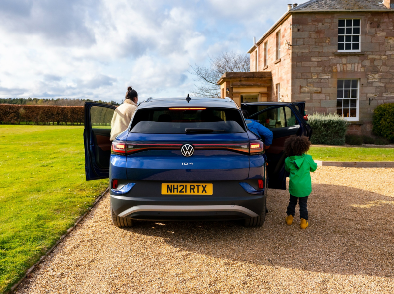 A family entering an ID.4 parked outside a cottage