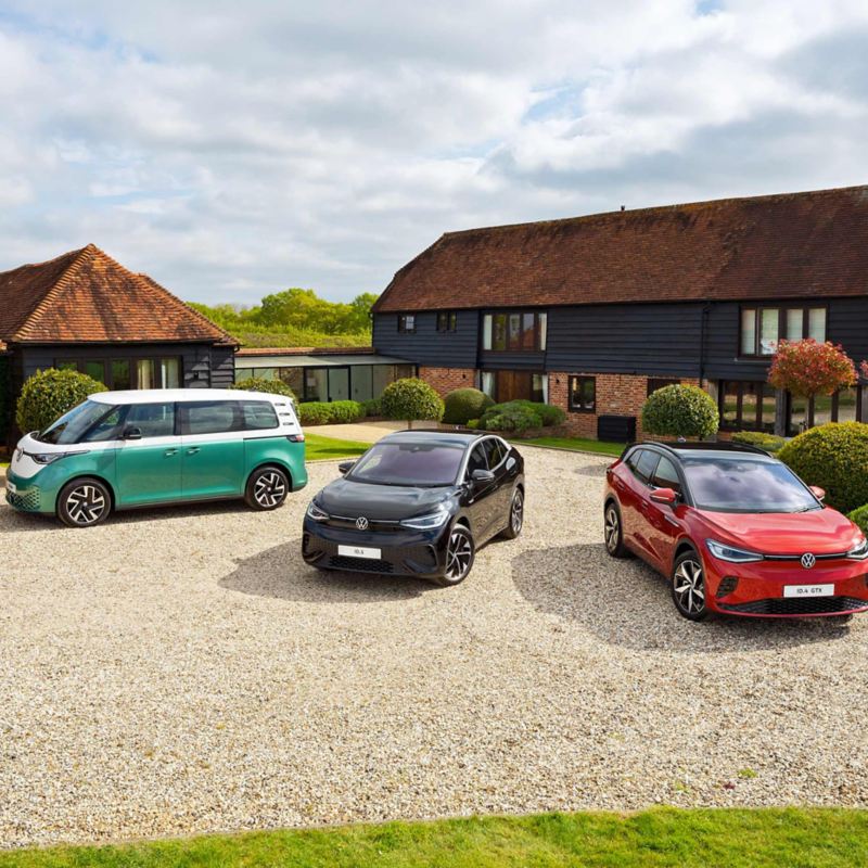 Photo showing three electric cars parked by the countryside. 
