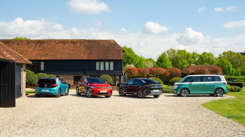 A range of the VW ID models lined up on a driveway of a country house