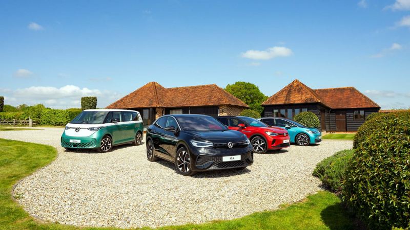 A range of the VW ID models lined up on a driveway of a country house