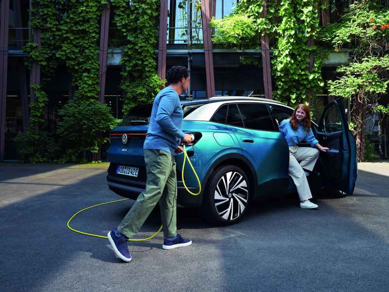 A man and woman beside an electric VW car