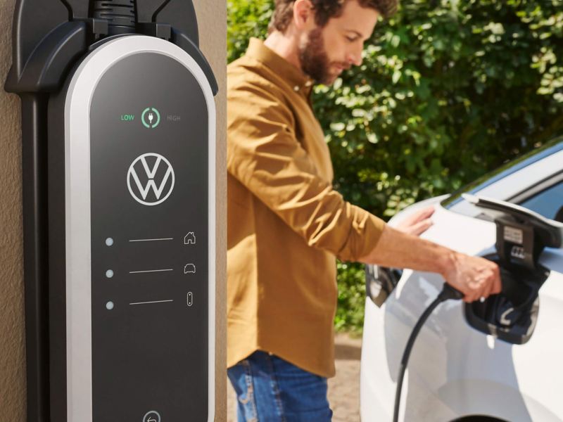 A man charging his electric VW vehicle