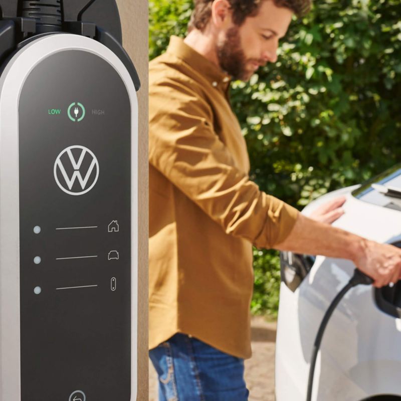 A man charging his electric VW vehicle