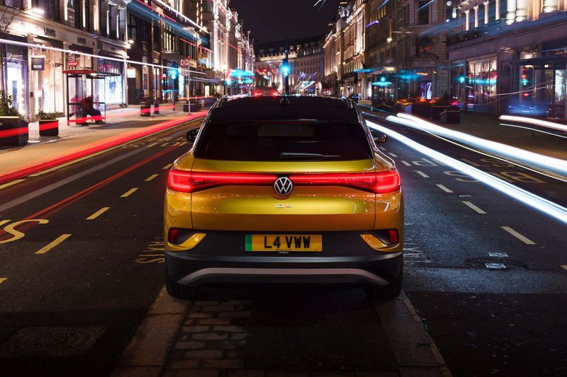 A yellow VW ID.4 parked in the middle of a road at night