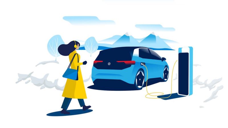 A person walks towards a charging VW id3 standing in a snowy mountain landscape