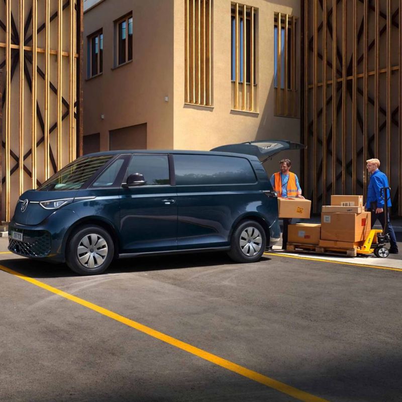 two people unload boxes from the boot of a navy blue ID. Buzz Cargo parked 