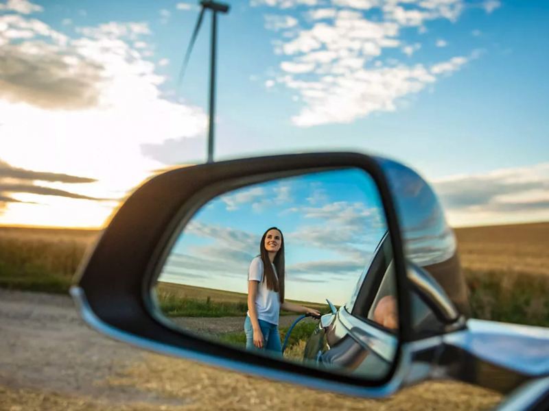 An image of a reflection of a woman in a car wing mirror
