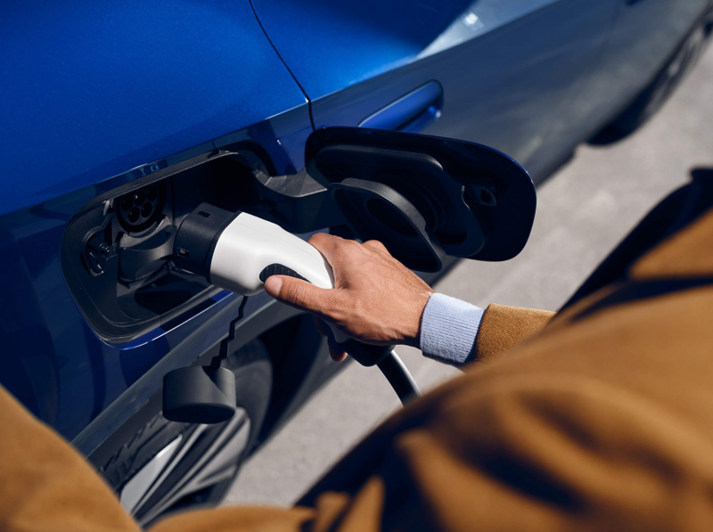 A person holding a charging plug into the socket of an ID.4