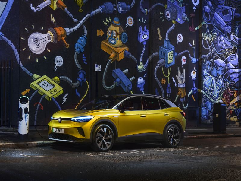 Volkswagen ID.4 parked at an inner city charging station next to a trendy graffitied wall