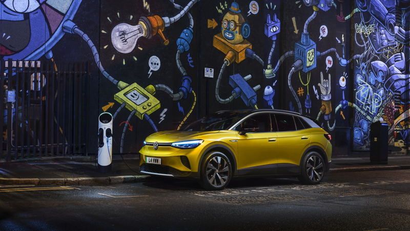 a yellow ID.4 in the city parked and plugged into a charger