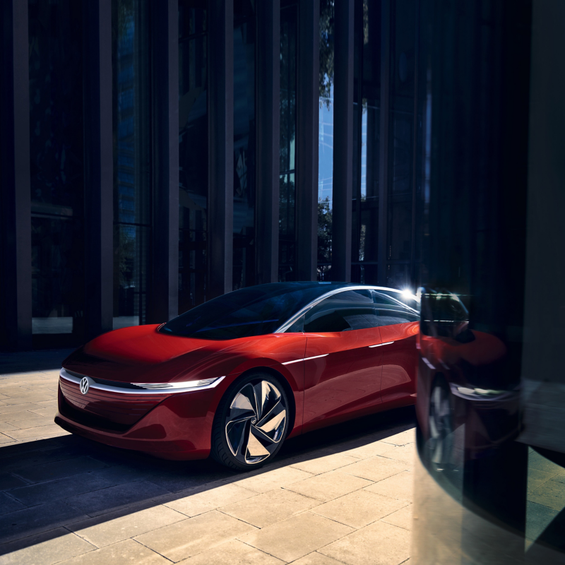 A red Volkswagen ID. VIZZION parked near office buildings