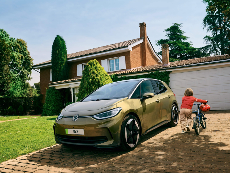 A child walking with a bike next to an ID.3 parked on a driveway