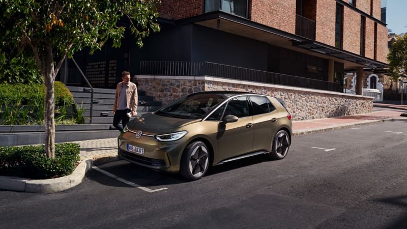 A view of a VW ID.3 in “Dark Olivine Green Metallic” and with “Sanya” wheels, parked on the side of the road. 