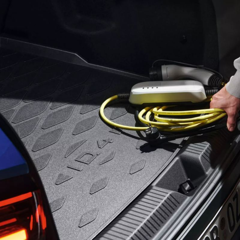 A lady about to plug an electric charging cable into her car