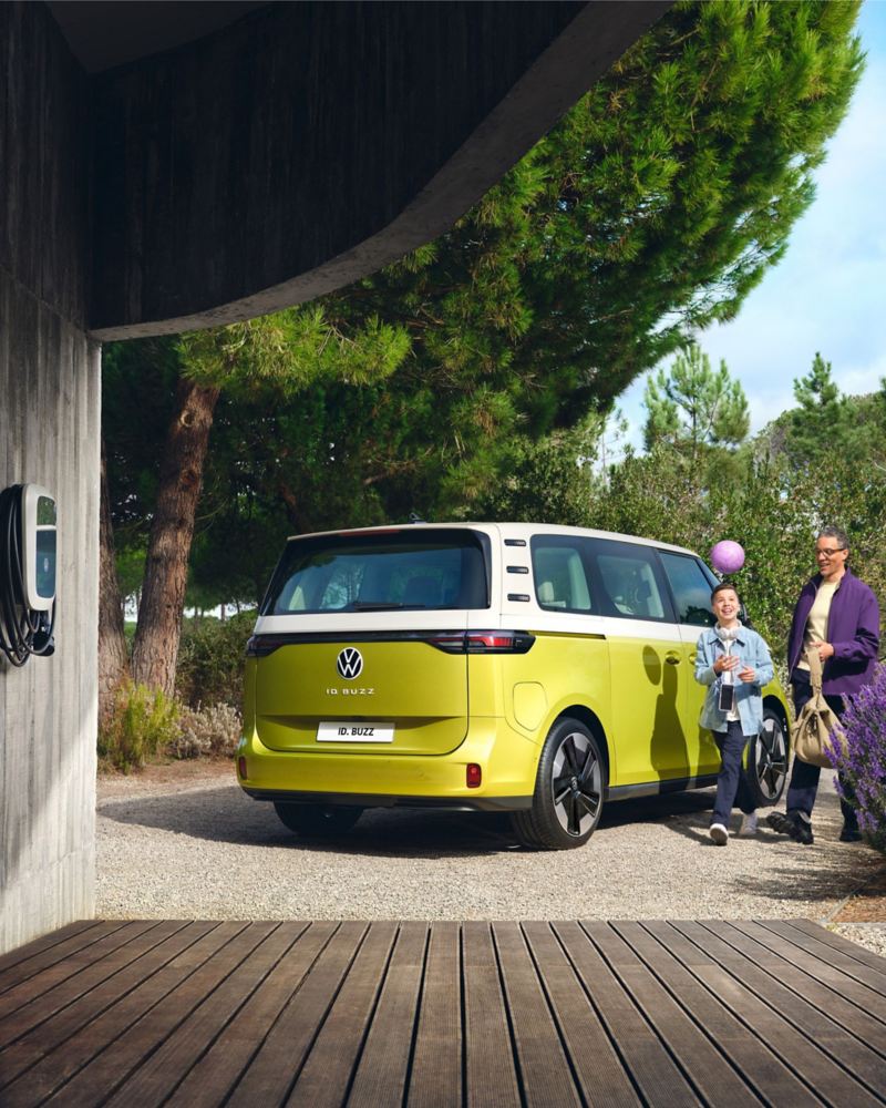 Parked VW ID. Buzz with parent and child walking beside the van