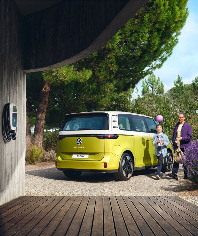 Parked VW ID. Buzz with parent and child walking beside the van