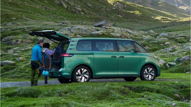A green ID. Buzz with its boot door opened and 2 people unloading it's content