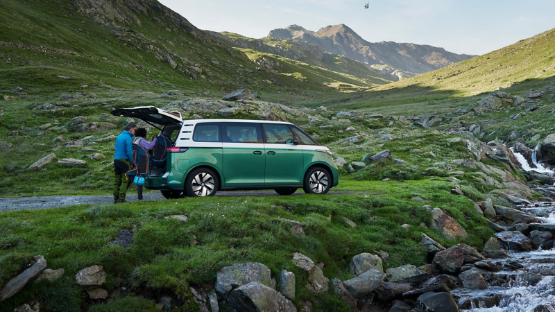 A two tone green and white VW ID.Buzz parked in the nature