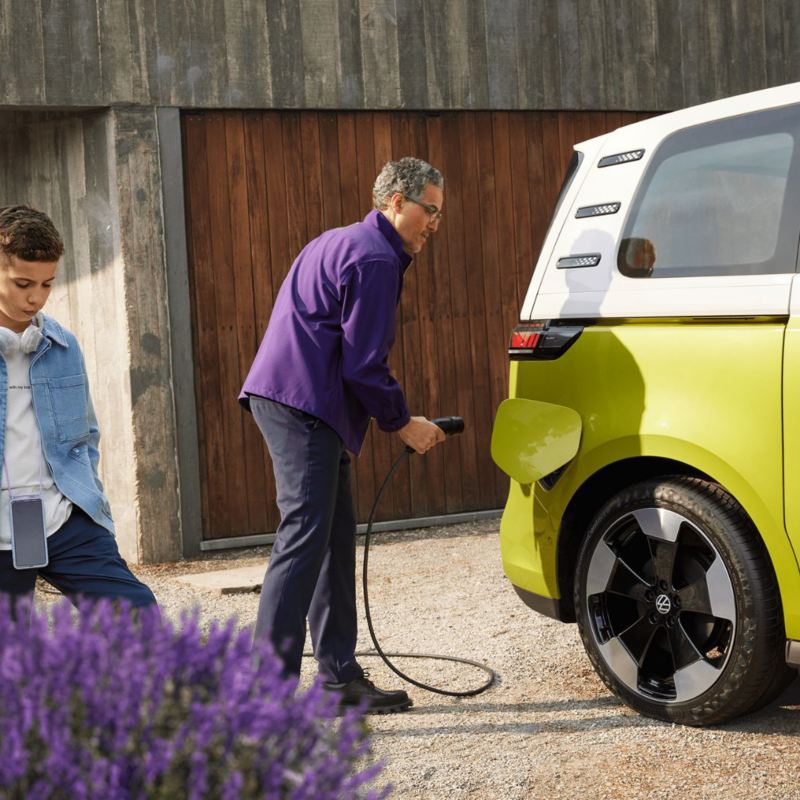 a man plugging a charger into a yellow ID.Buzz