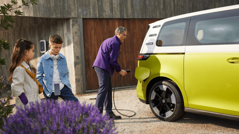 a man plugging a charger into a yellow ID.Buzz