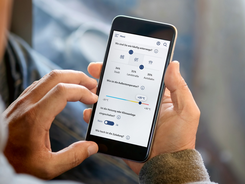 Hand holding mobile phone displaying range simulator