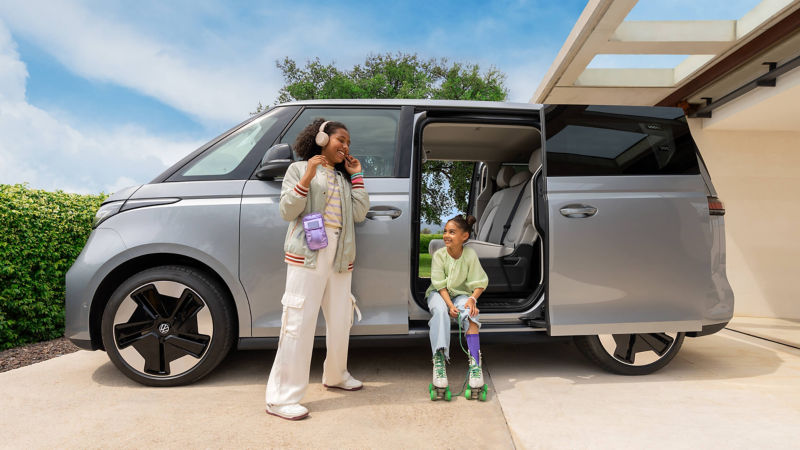 Two children standing next to an ID. Buzz with the side door open. 