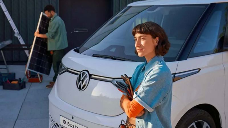 Two solar panel install workers standing next to a parked ID. Buzz Cargo. 