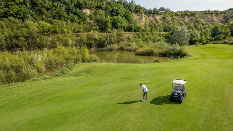 Silvan Widmer si trova sul campo da golf accanto al suo golf cart