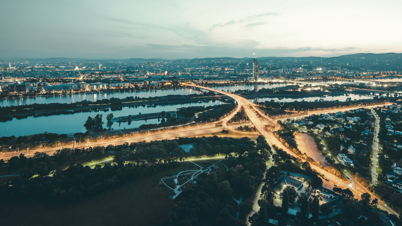 Eine beleuchtete Autobahnauffahrt bei Dämmerung von weit oben