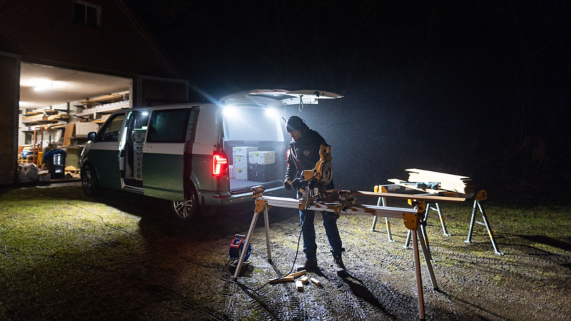 Snickare använder en kap/gersåg bakom en VW Transporter