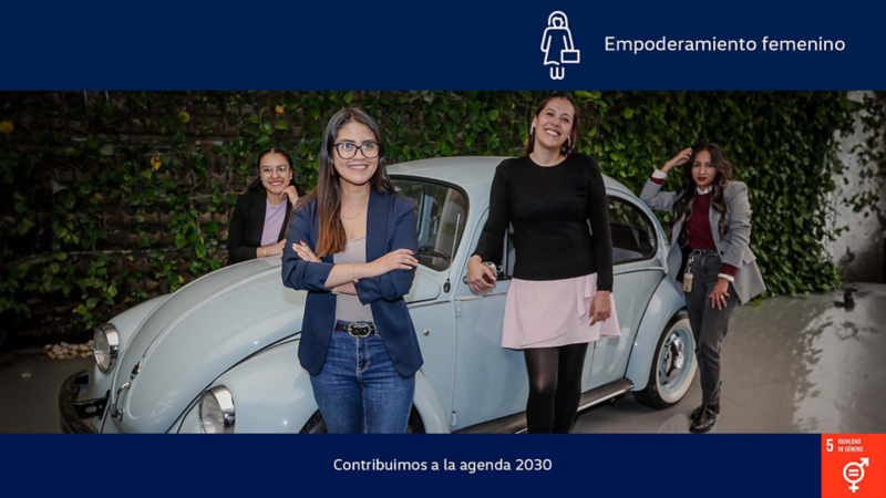 Mujeres posan junto a un Volkswagen Sedán clásico color azul claro.