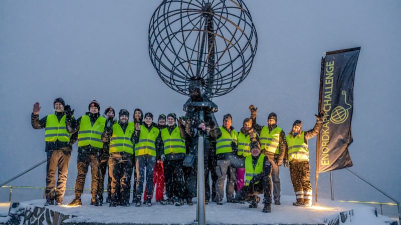 Die Gruppe steht am Nordkapp mit Schutzwesten