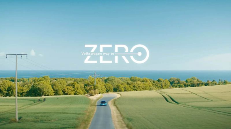 Logo de Way To Zero con carretera donde transita un auto eléctrico. 