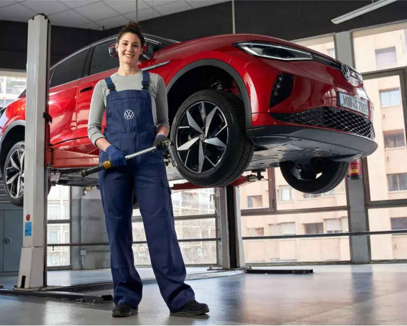 Técnico certificado de VW frente a un VE de Volkswagen.