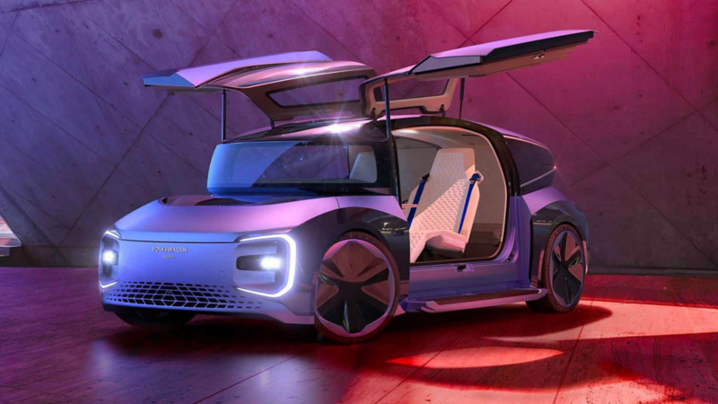 Le concept-car GEN.TRAVEL garé dans un endroit clos, montre son design futuriste avec ses portières paillons ouvertes.
