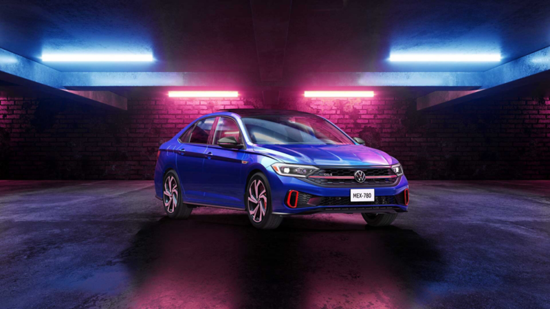 Jetta GLI 2022 en color azul iluminado por luces de neón en un garage.