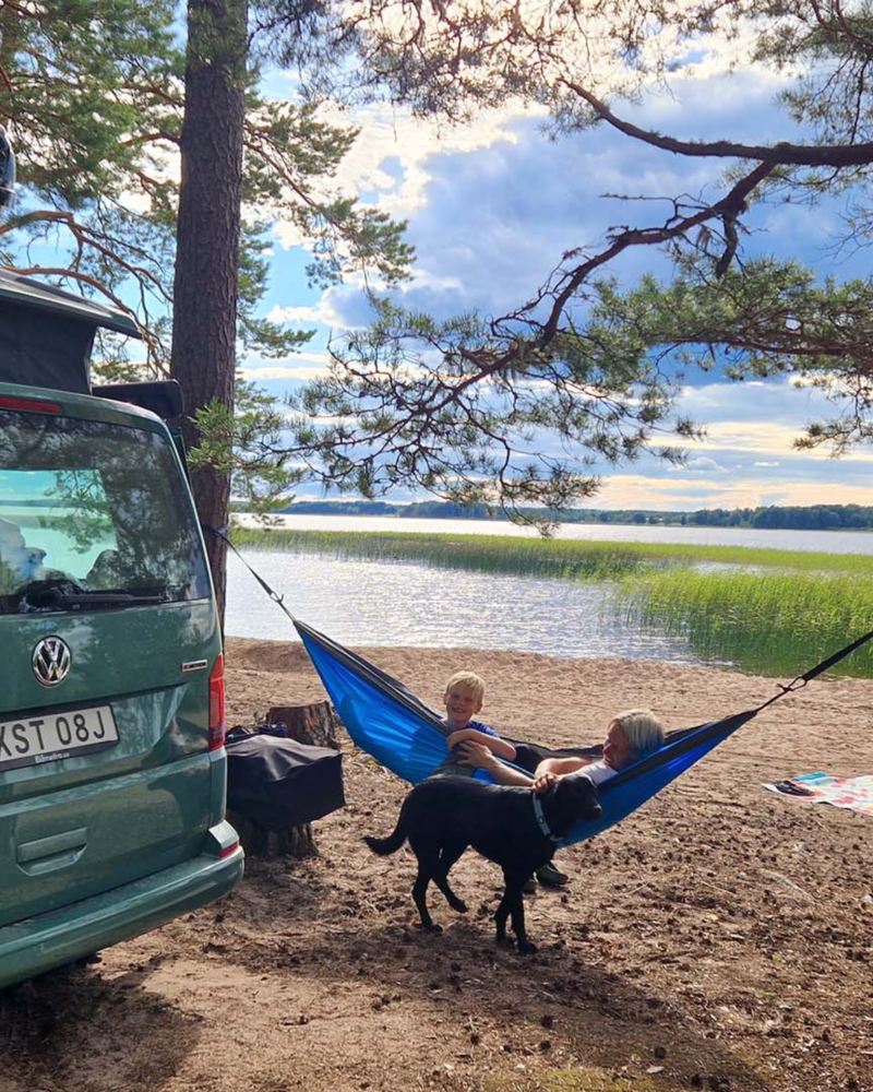 VW California Ocean framför en hängmatta med barn och hund