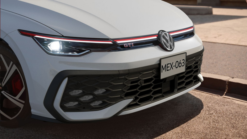 Parrilla tipo panal de GTI 2025 con luces LED delanteras, labio superior y logo VW iluminados.