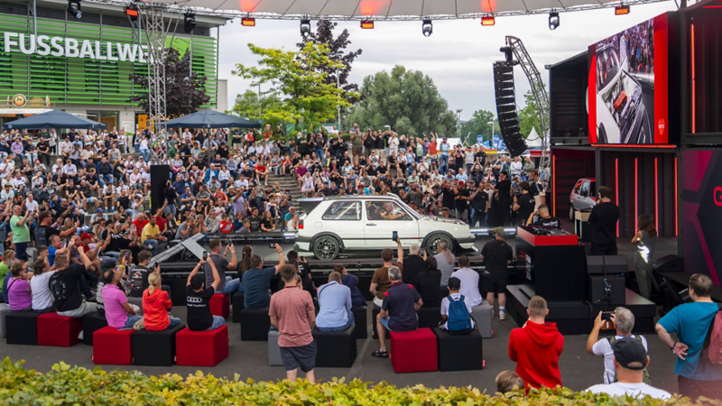 La foule se rassemble autour d'une Golf GTI mkII en pleine présentation.