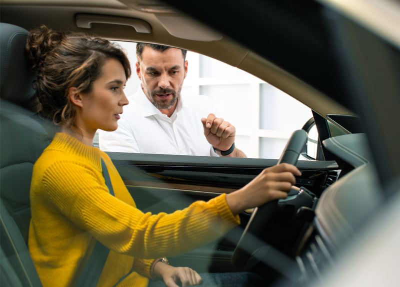 Femme dans un véhicule chez un concessionnaire Volkswagen, lien vers la page de recherche de concessionnaires VW
