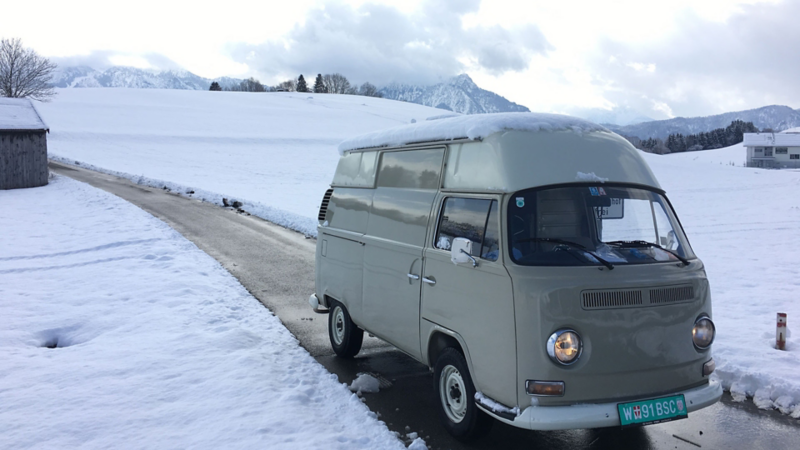 Klassischer Volkswagen Bus in verschneiter Winterlandschaft.
