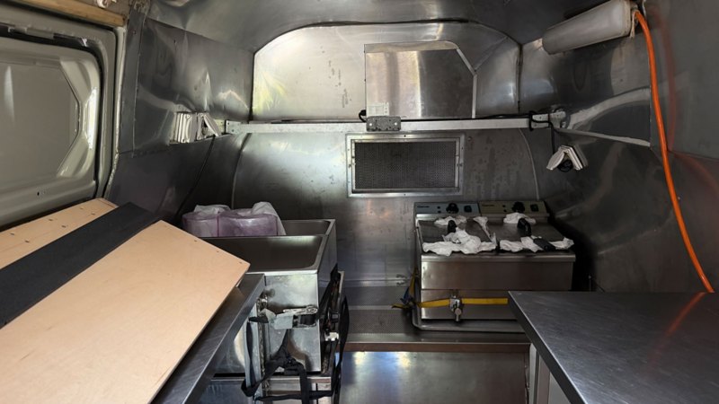 Innenausstattung eines Foodtrucks mit professioneller Kücheneinrichtung.