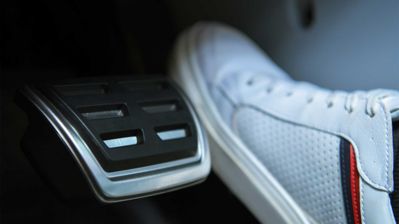 Zapato de conductor pisa acelerador de un auto Volkswagen. 