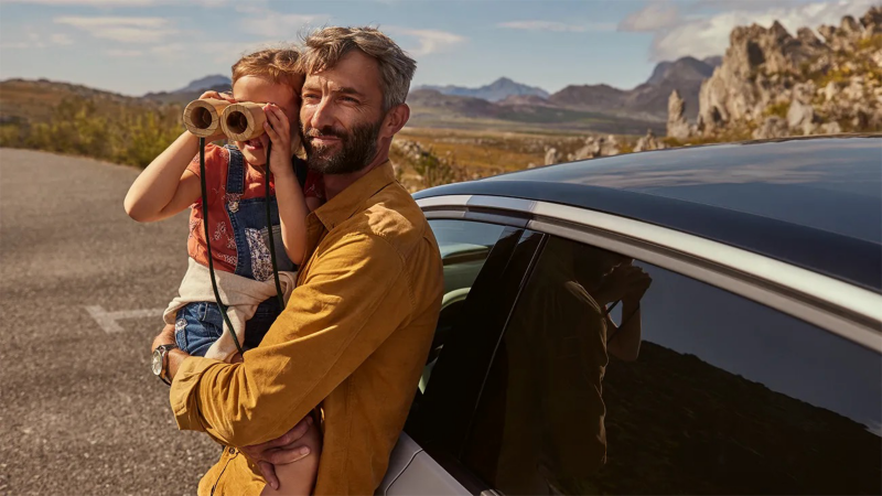 dad with kid next to volkswagen