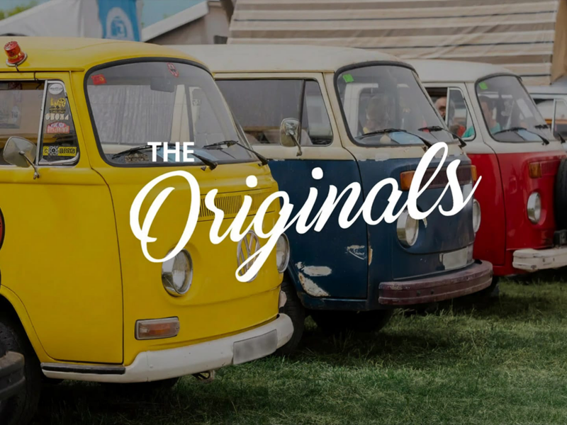 Varias furgonetas Volkswagen clásicas aparcadas sobre un césped