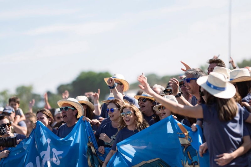 Personas animando a sus ganadores en un día soleado y con sombreros de paja