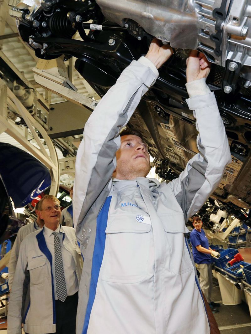Marco Reus arbeitet am Unterboden eines Fahrzeuges