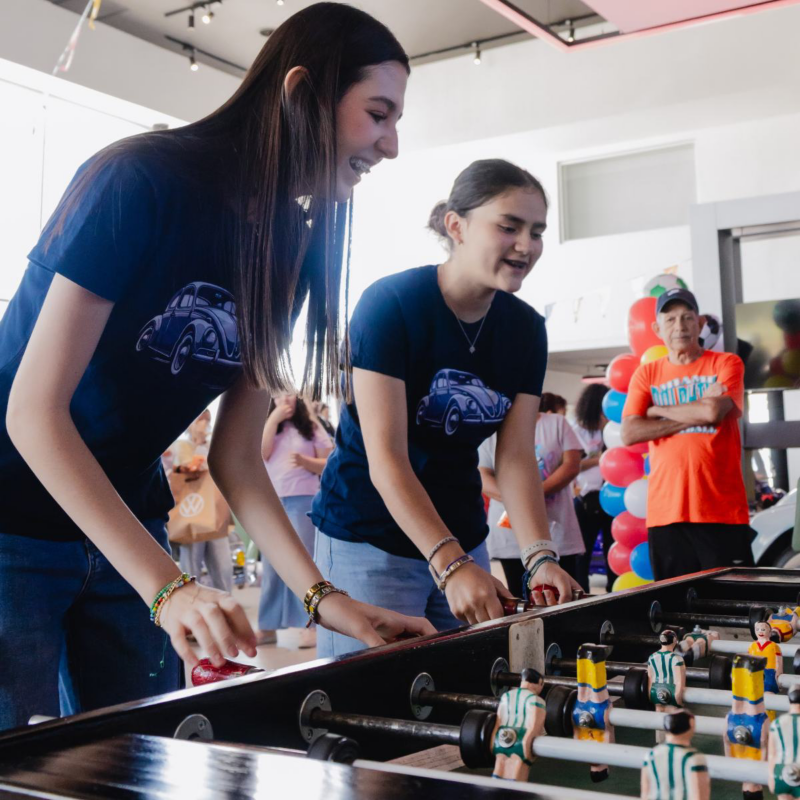 Dos mujeres jóvenes juegan futbolito durante evento de Vocho Fest 2026.