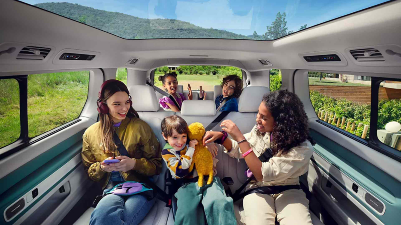 the inside of an ID Buzz, with kids the backseat playing around