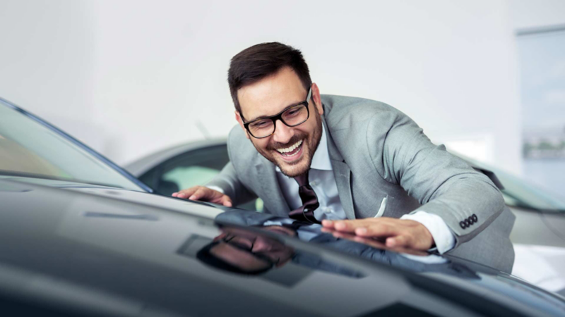 Hombre con lentes toca auto de Volkswagen que le interesa comprar.